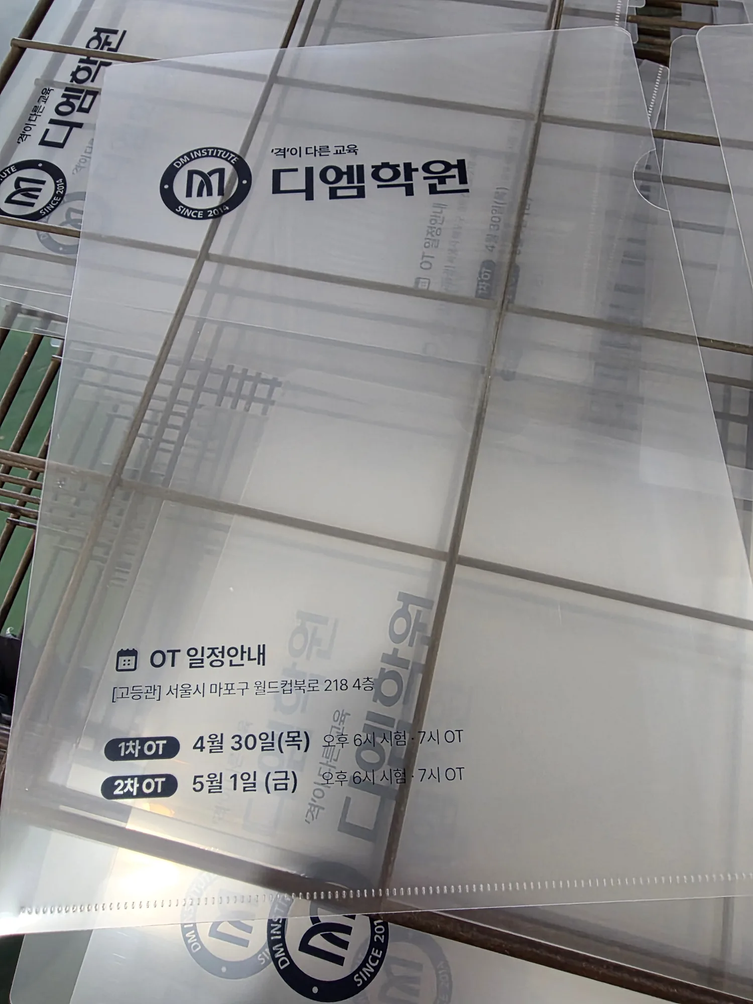 투명 PP L홀더가 여러 장 겹쳐 쌓여 인쇄 내용이 보이는 모습