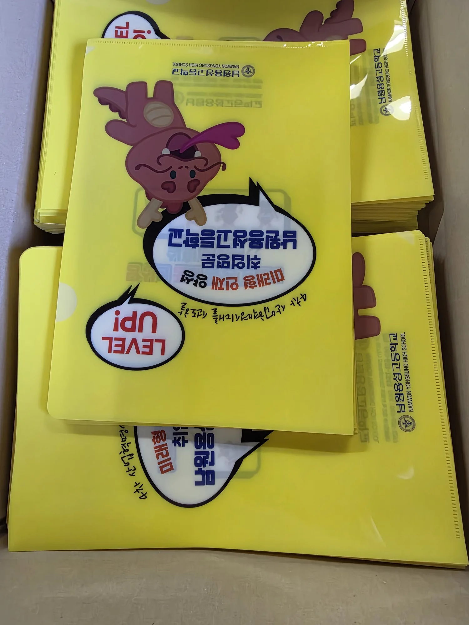 노란색 인쇄 L홀더가 여러 장 겹쳐 쌓인 모습